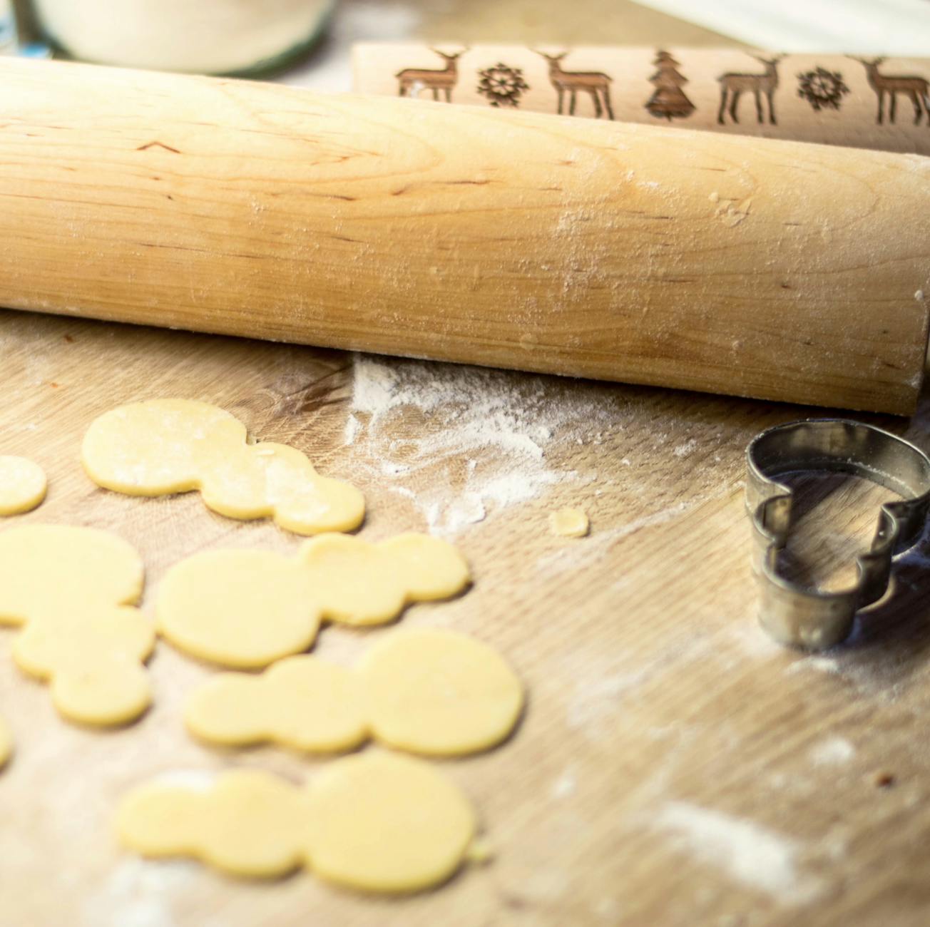 Świąteczne ciasteczka w kształcie bałwanków na drewnianej desce