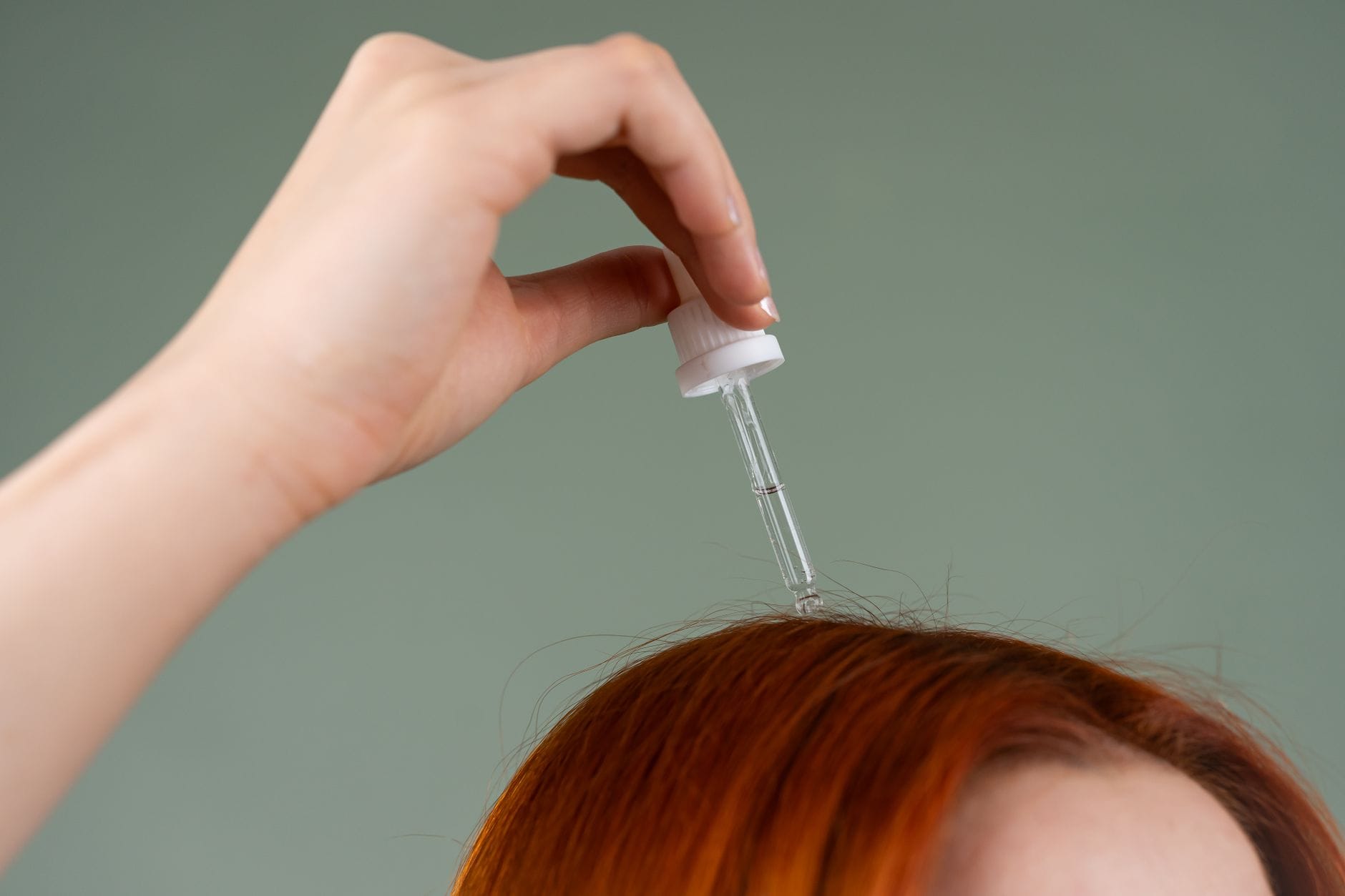 Polskie kosmetyki do skóry głowy: wcierki, peelingi i toniki, które mają sens Aplikacja wcierki pipetą na rude włosy z bliska